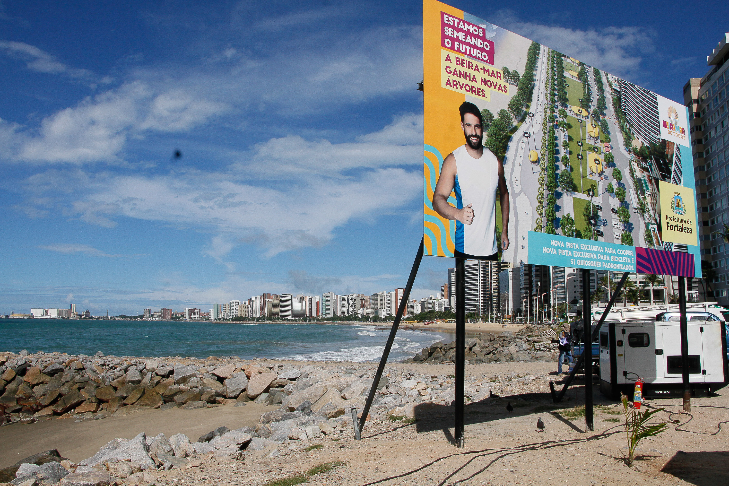 placa de obra instalada no calçadão da beira=mar